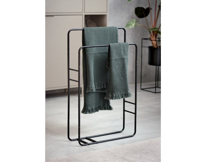 Freistehender Handtuchhalter aus schwarzem Metall mit offener Rahmenkonstruktion und abgerundeten Kanten im Badezimmer.