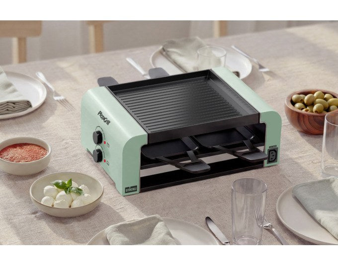 Tischgrill STÖCKLI PizzaGrill 4 Connect in mint green mit vier Pfännchen, Wende-Grillplatte und Teigausstecher auf hellem Hintergrund.