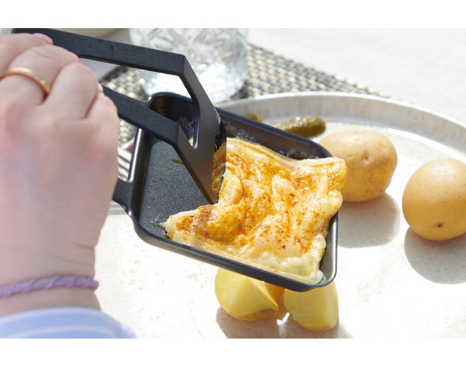 Mint grüner STÖCKLI CheeseGrill 4 Connect mit vier antihaftbeschichteten Pfännchen und wendbarer Aluguss-Grillplatte auf hellem Hintergrund.
