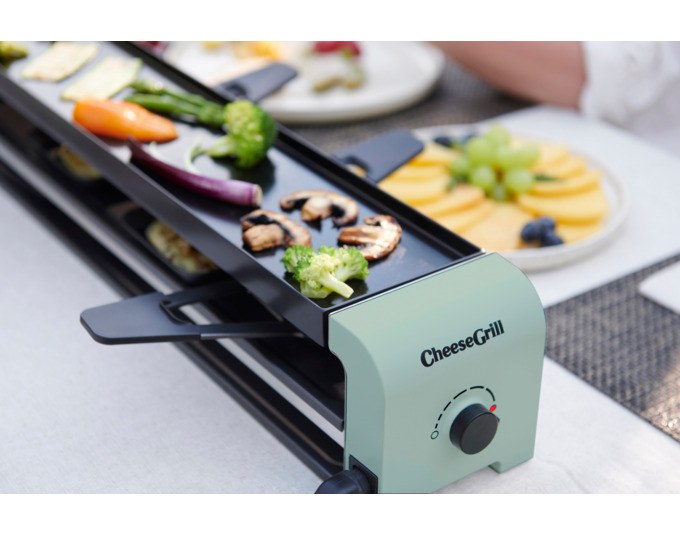 Mint grüner STÖCKLI CheeseGrill 4 Connect mit vier antihaftbeschichteten Pfännchen und wendbarer Aluguss-Grillplatte auf hellem Hintergrund.