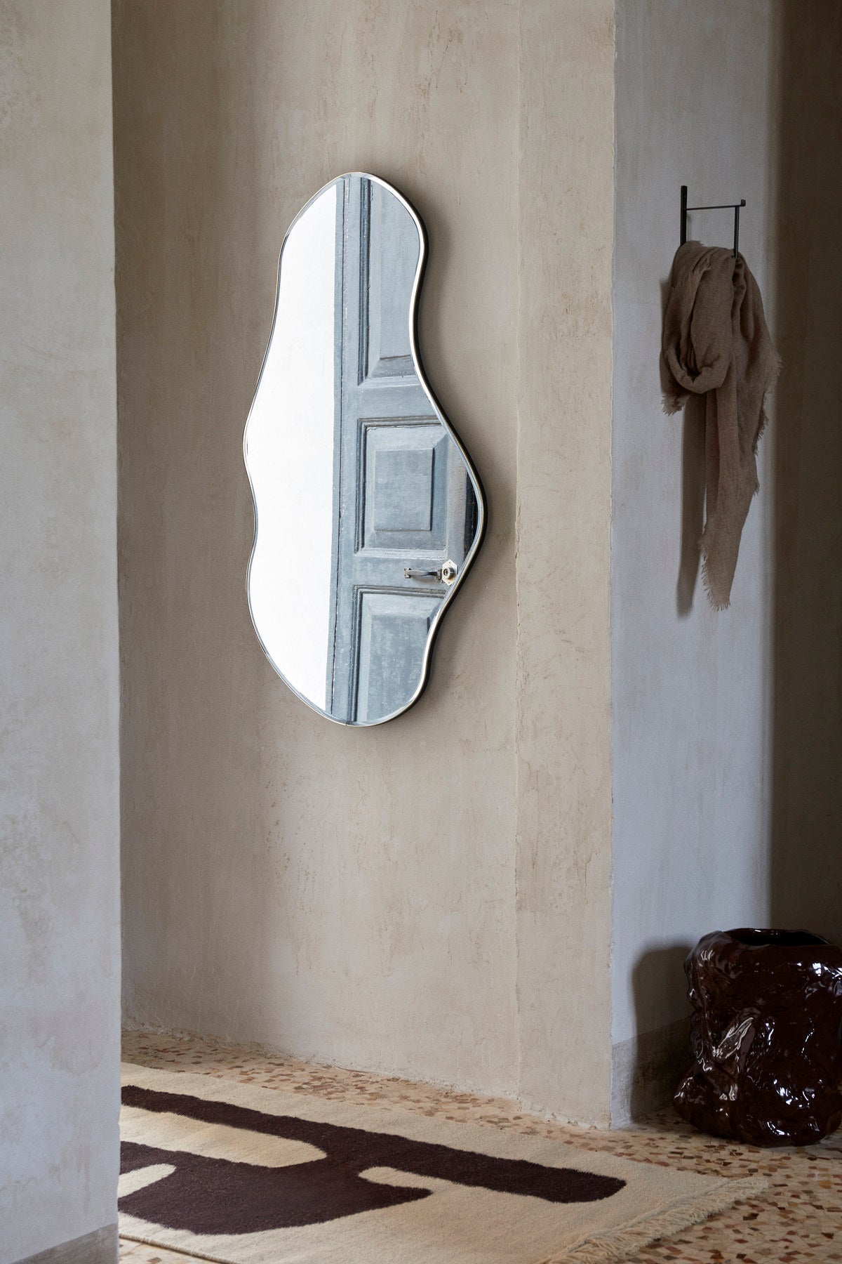 Pond Spiegel von Ferm Living in Messing: Wandspiegel mit organisch geschwungener Form, MDF-Rückwand und messingbeschichtetem Zinkrahmen, 87x94cm.