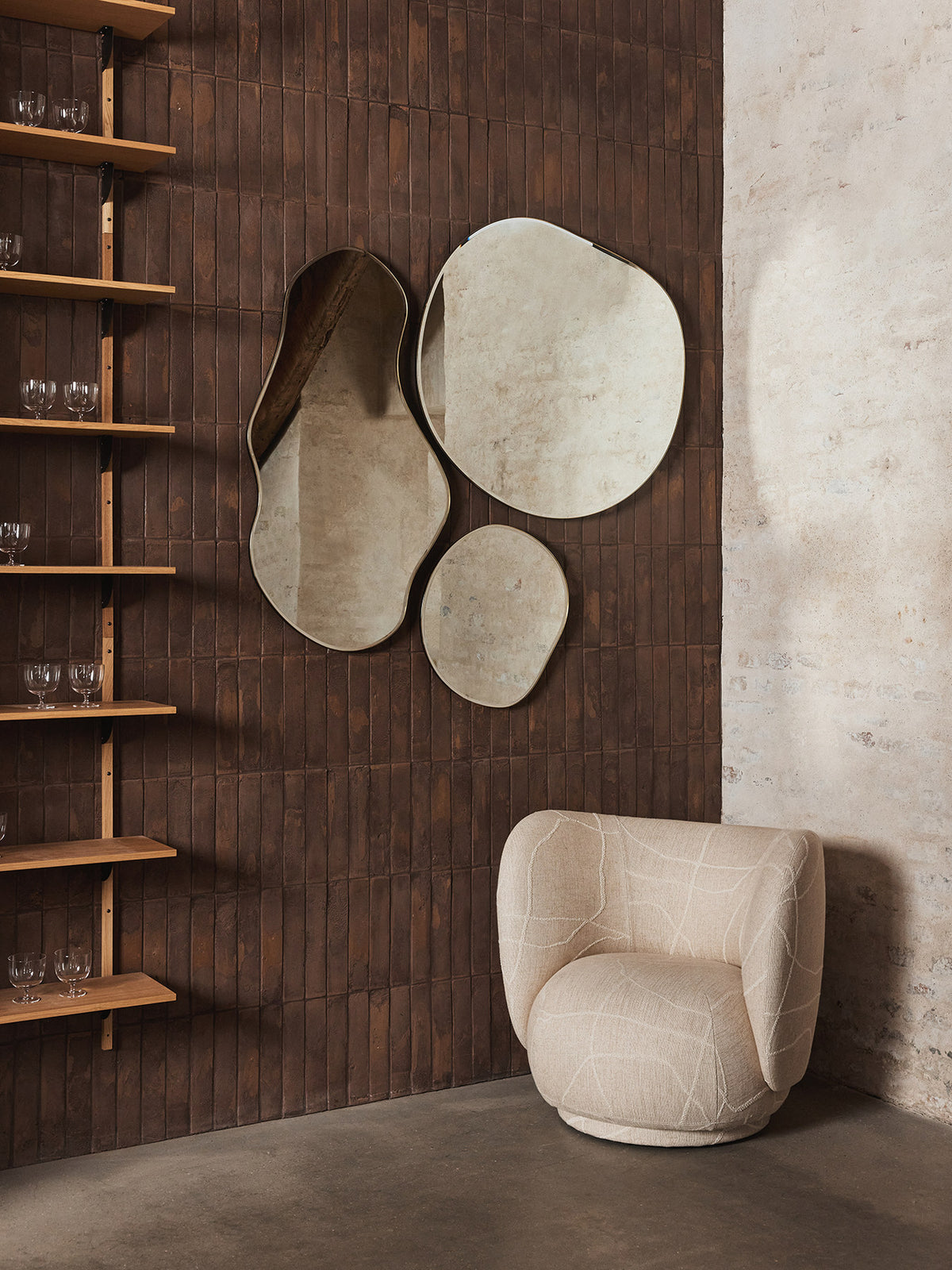 Pond Spiegel von Ferm Living in Messing: Wandspiegel mit organisch geschwungener Form, MDF-Rückwand und messingbeschichtetem Zinkrahmen, 87x94cm.