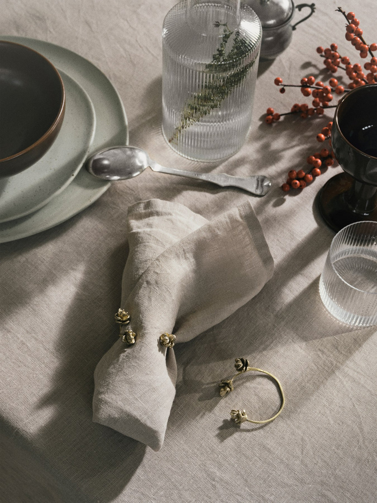 Vier Serviettenringe aus massivem Messing der Forest-Serie von Ferm Living mit fein detaillierter, gewellter Oberfläche, freigestellt fotografiert.