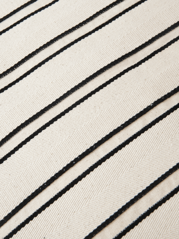 Elegantes rechteckiges Kissen aus Twill in sanften Off-white- und Schwarz-Nuancen, perfekt für ein modernes Ambiente und stilvolle Akzente.