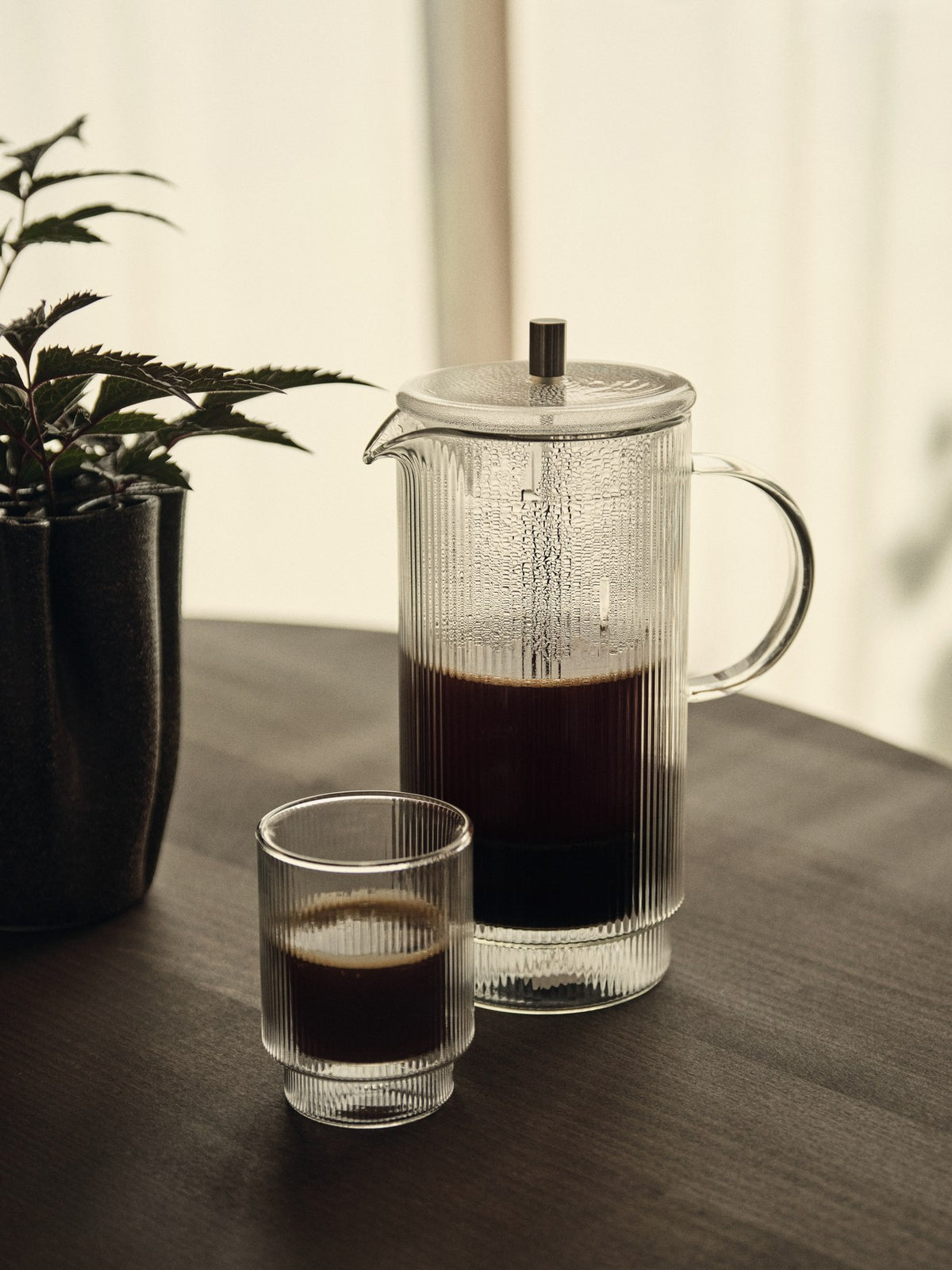 Doppelwandige French Press aus mundgeblasenem Glas mit geriffelter Oberfläche und Edelstahl-Deckel, transparent, zylindrische Form.