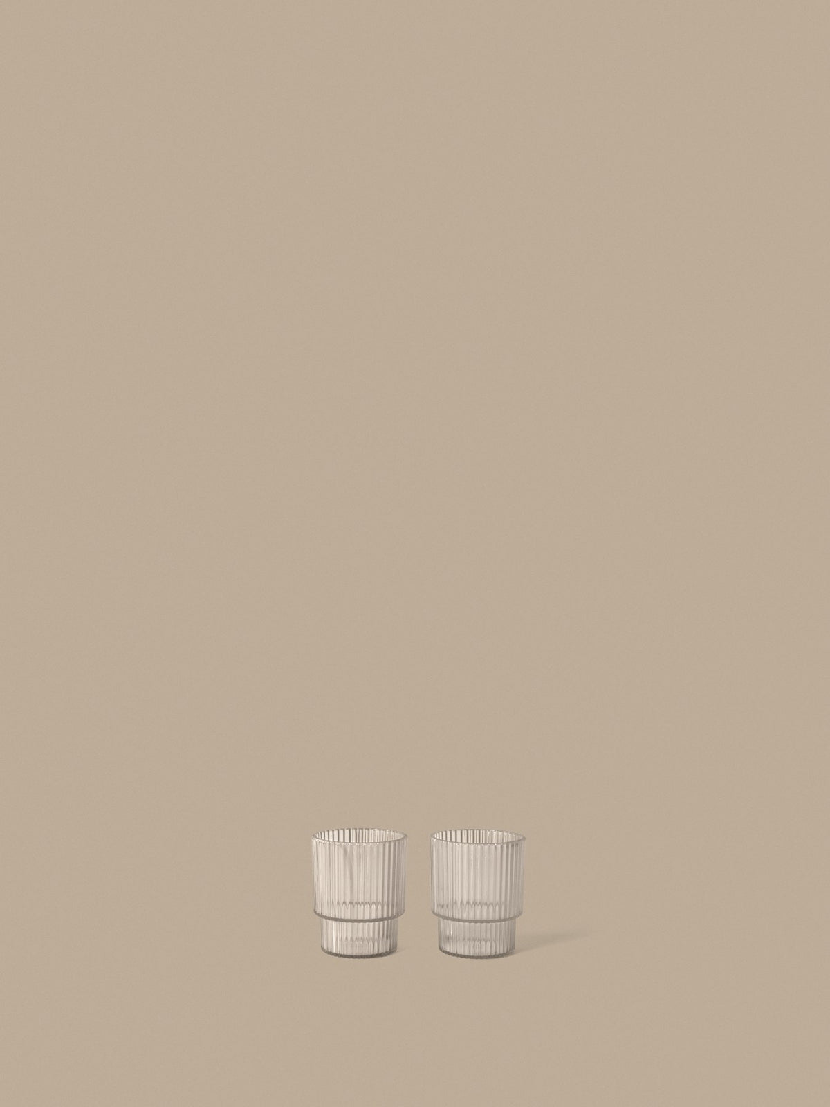 Zwei Ripple Kinder-Becher von Ferm Living aus klarem Tritan-Kunststoff mit geriffelter Oberfläche und geometrischer, runder Silhouette.