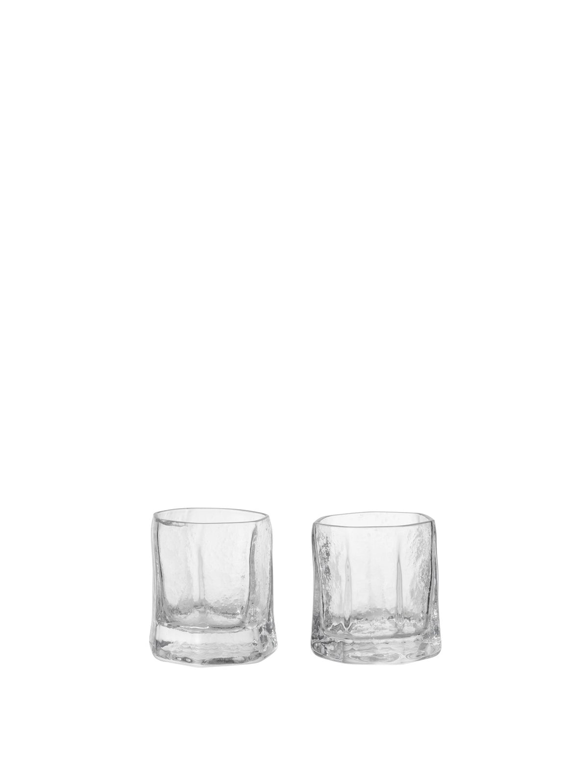 Zwei klare Kiru Gläser von Ferm Living aus mundgeblasenem recyceltem Glas mit skulpturaler, keramikähnlicher Oberflächenstruktur auf hellem Hintergrund.