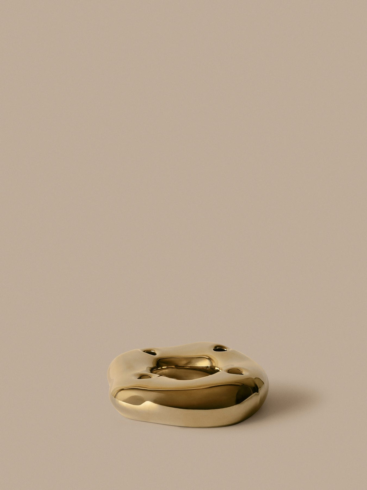 Ring-Kerzenhalter Bellure von Ferm Living aus galvanisiertem Porzellan in Messing-Finish, organische Ringform für vier Kerzen.