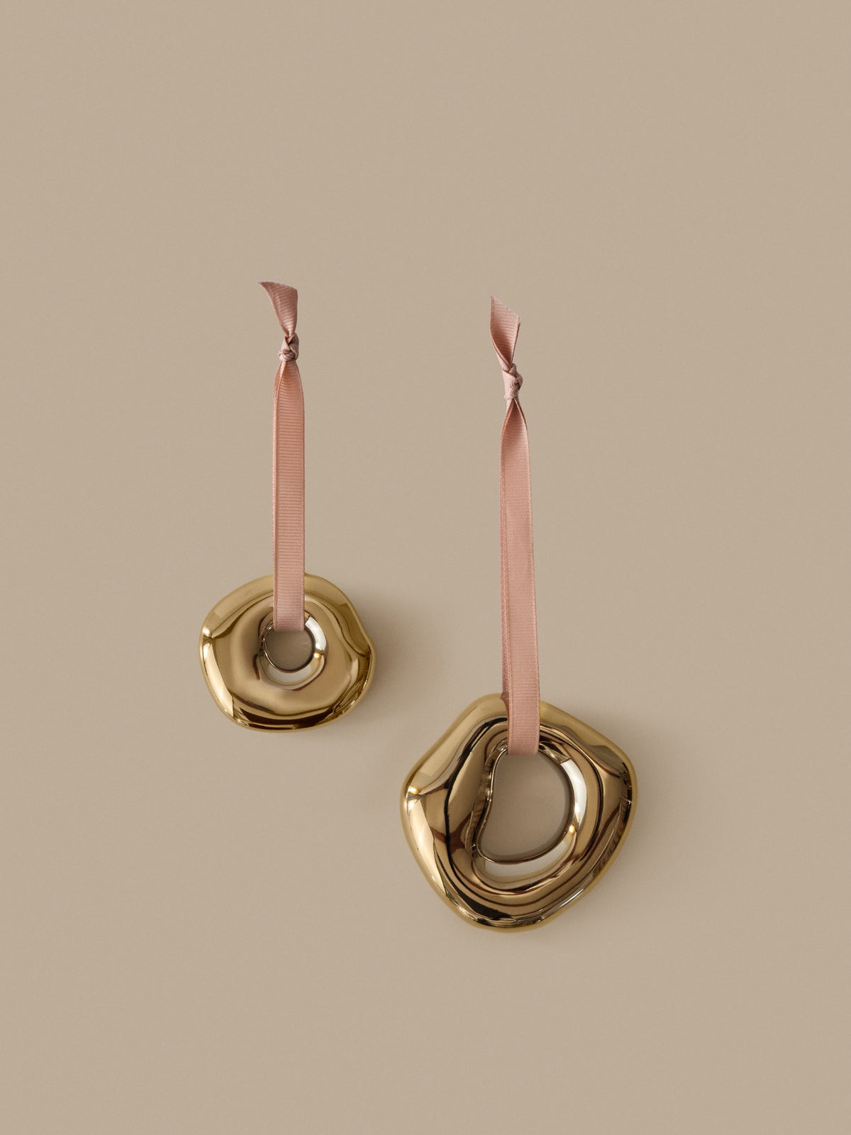 Zwei runde Ornamente aus galvanisiertem Steingut in Messing-Finish mit Polyesterband, abstrakte organische Form, Weihnachtsdekoration.