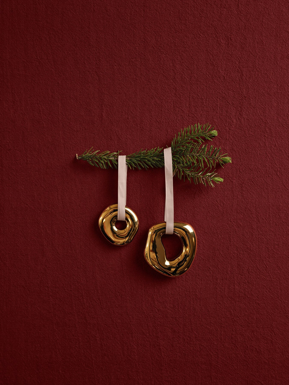 Zwei runde Ornamente aus galvanisiertem Steingut in Messing-Finish mit Polyesterband, abstrakte organische Form, Weihnachtsdekoration.