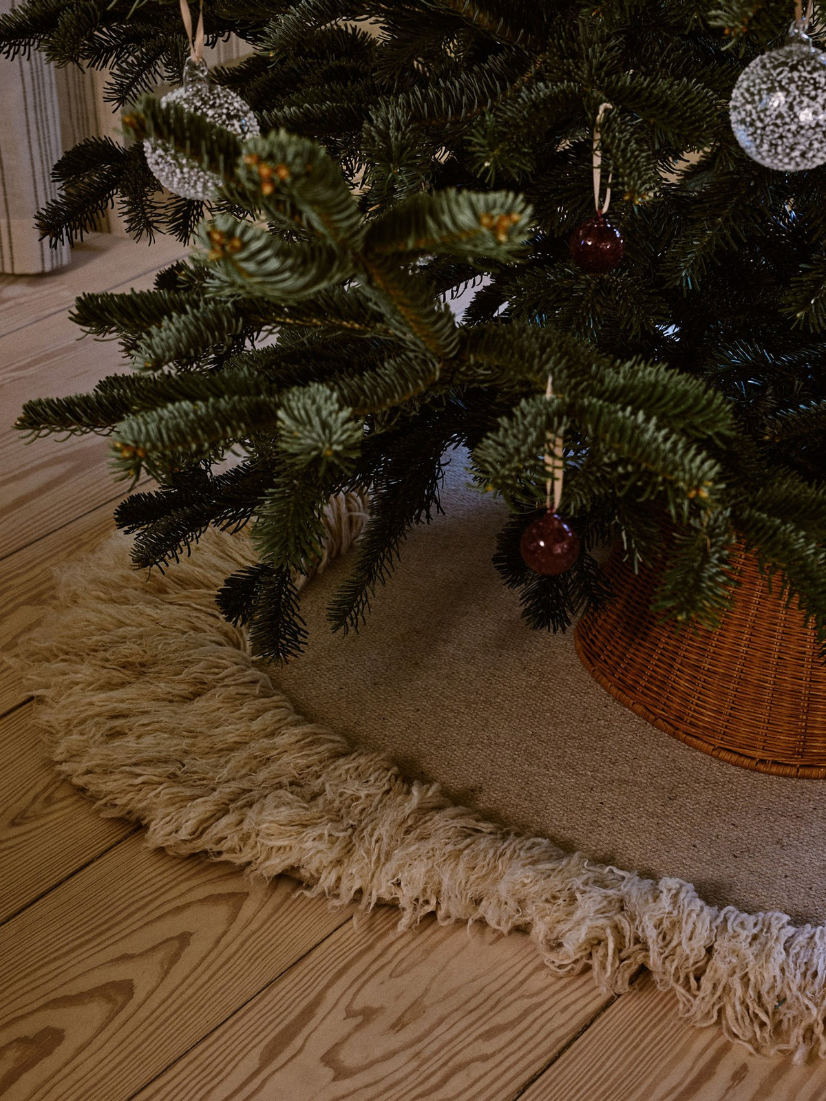 Drei mundgeblasene Glaskugeln in Picante Rot mit strukturierter, kristalliner Oberfläche, an cremefarbenem Polyesterband hängend.