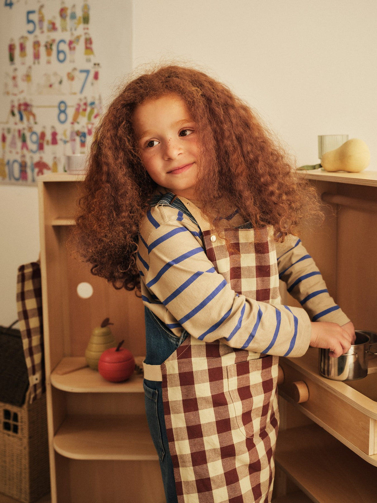 Bothy Kinderküchen-Set von Ferm Living: Schürze, Ofenhandschuh und Geschirrtuch aus Bio-Baumwolle im Karomuster, Farbe Zimt/Graugrün.