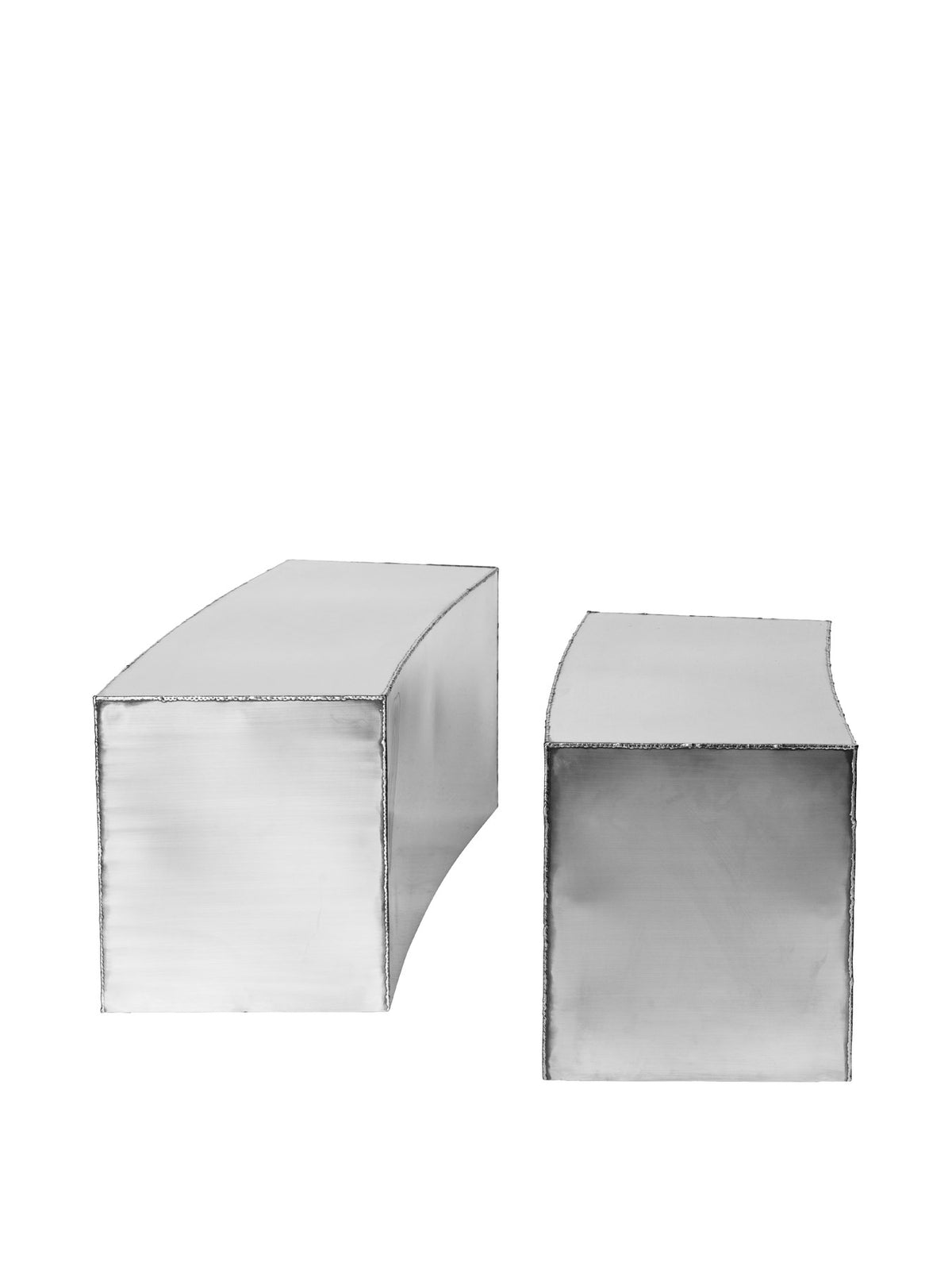 Ferra Couchtisch von Ferm Living aus gebürstetem Edelstahl mit sichtbaren, handverschweissten Kanten und leicht geschwungener Form.