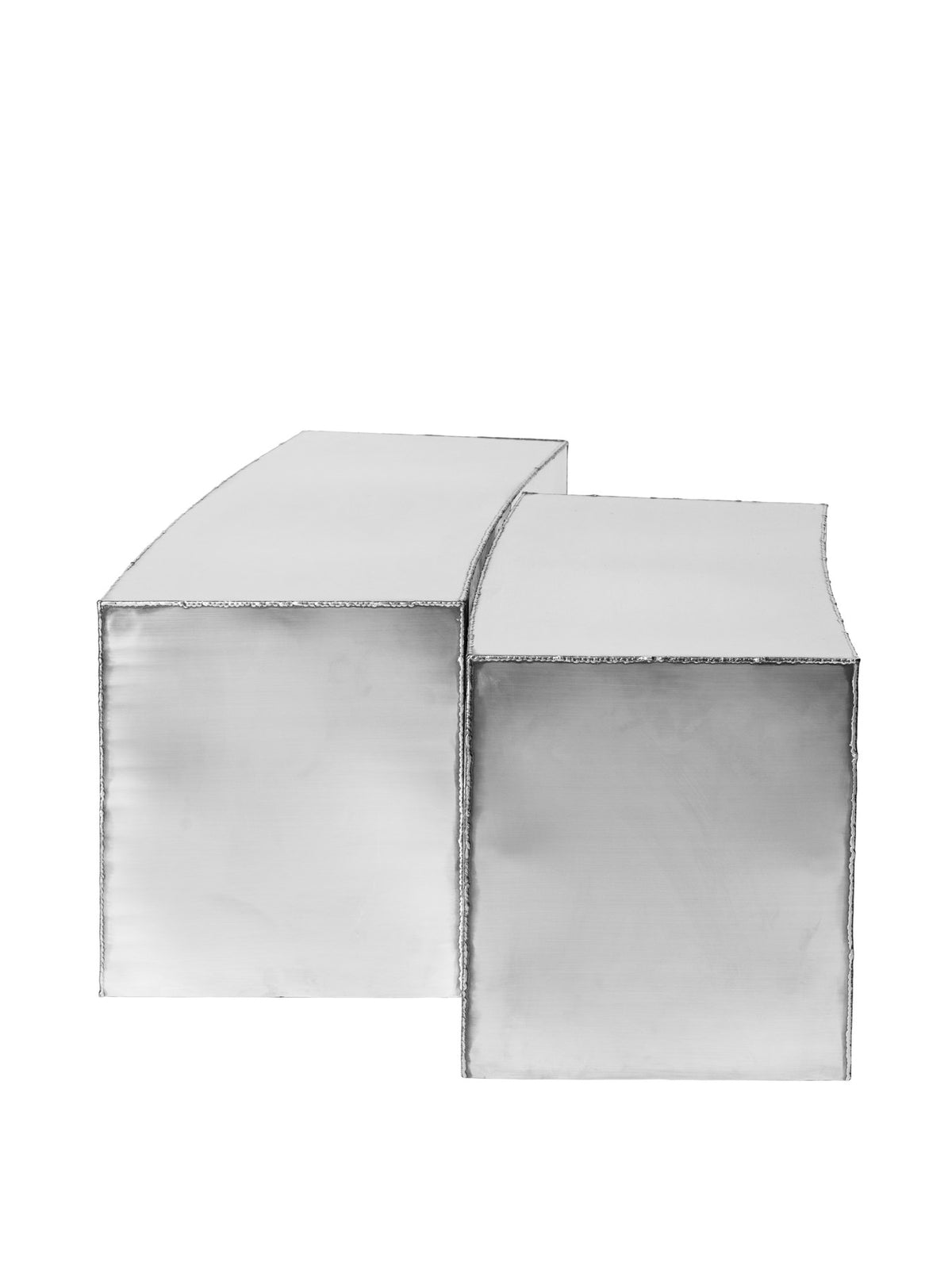 Ferra Couchtisch von Ferm Living aus gebürstetem Edelstahl mit sichtbaren, handverschweissten Kanten und leicht geschwungener Form.