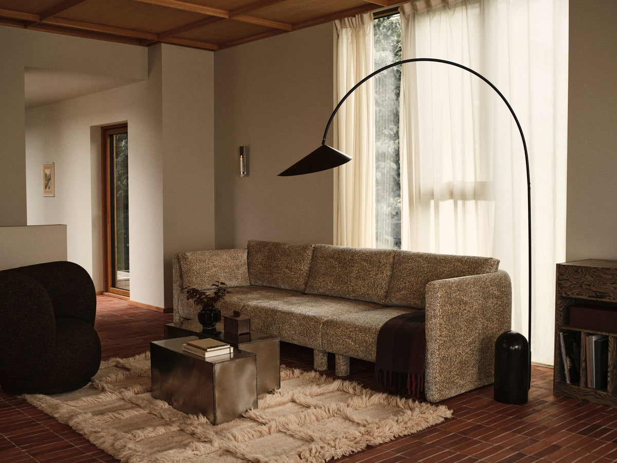 Ferra Couchtisch von Ferm Living aus gebürstetem Edelstahl mit sichtbaren, handverschweissten Kanten und leicht geschwungener Form.