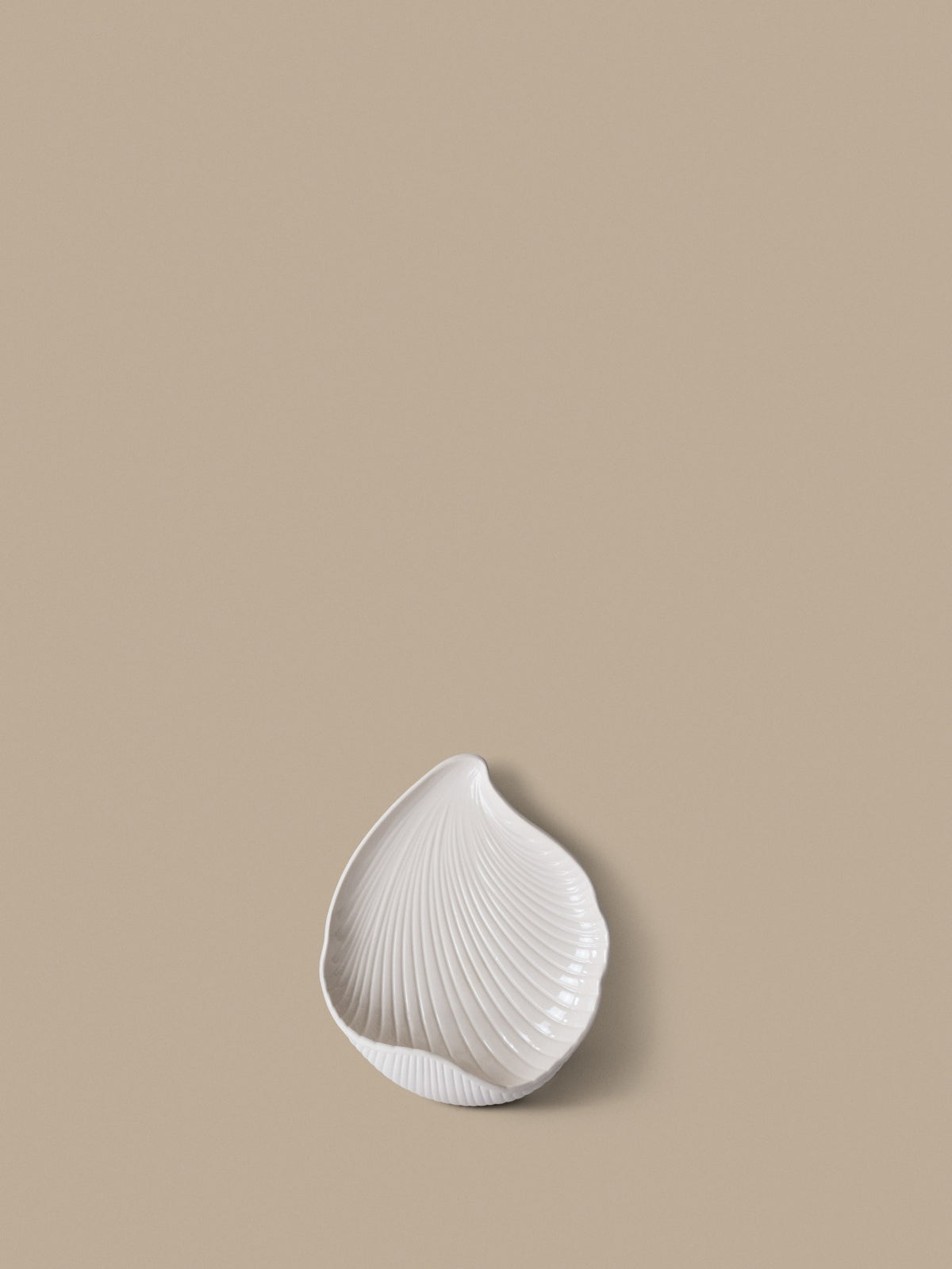 Wandkerzenhalter Shell von Ferm Living aus Steingut in Off-White, muschelförmig, Oberseite glasiert und Unterseite unglasiert.