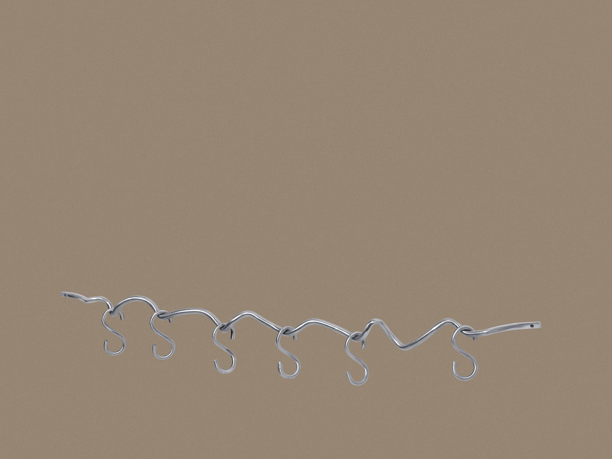 Produktfoto der Curvature Hängestange von Ferm Living aus massivem Messing mit matter Politur, inklusive sechs Haken, geschwungene Form.