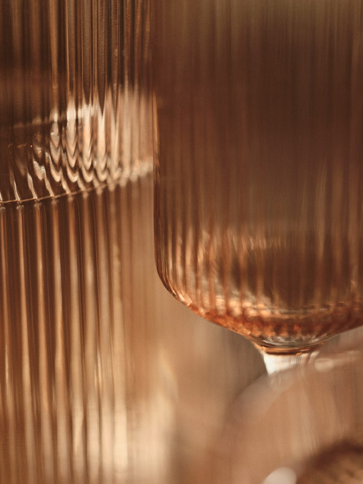 Zwei Ripple Champagnerflöten von Ferm Living aus mundgeblasenem Glas mit geriffelter Oberfläche, Farbe Blush, schlanke geometrische Form.