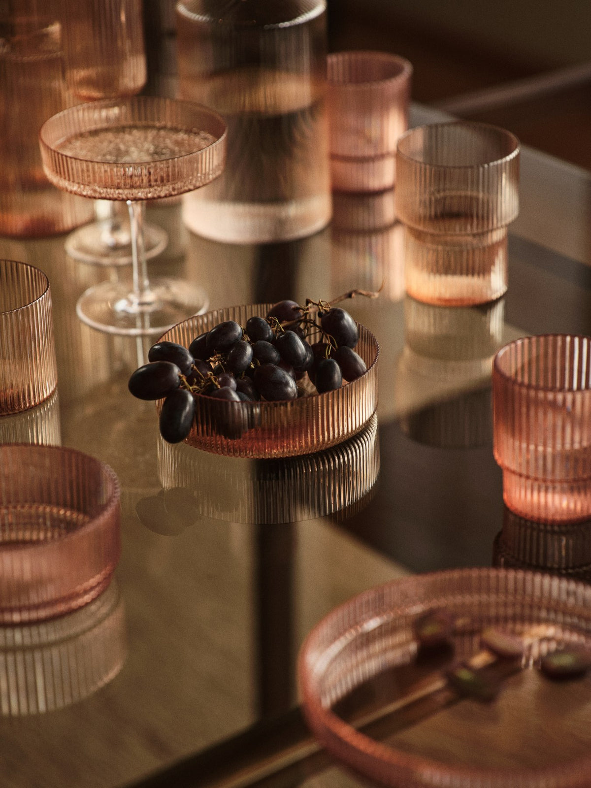 Vier Servierschüsseln aus mundgeblasenem Glas mit geriffelter Oberfläche, Farbe Blush, runde geometrische Form.