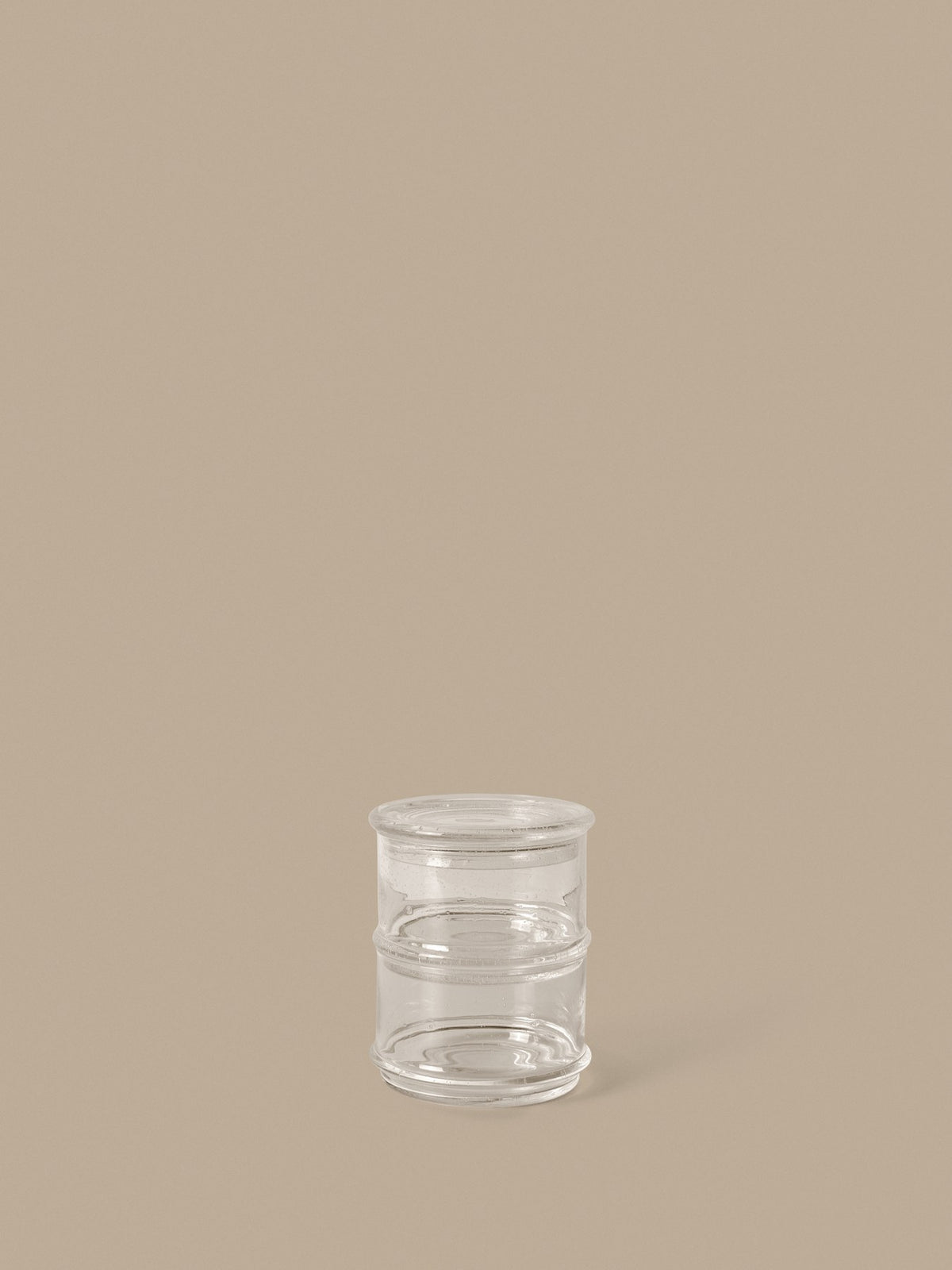 Zwei stapelbare Glasbehälter mit gemeinsamem Deckel aus klarem, mundgeblasenem Recyclingglas, rund und kompakt geformt.