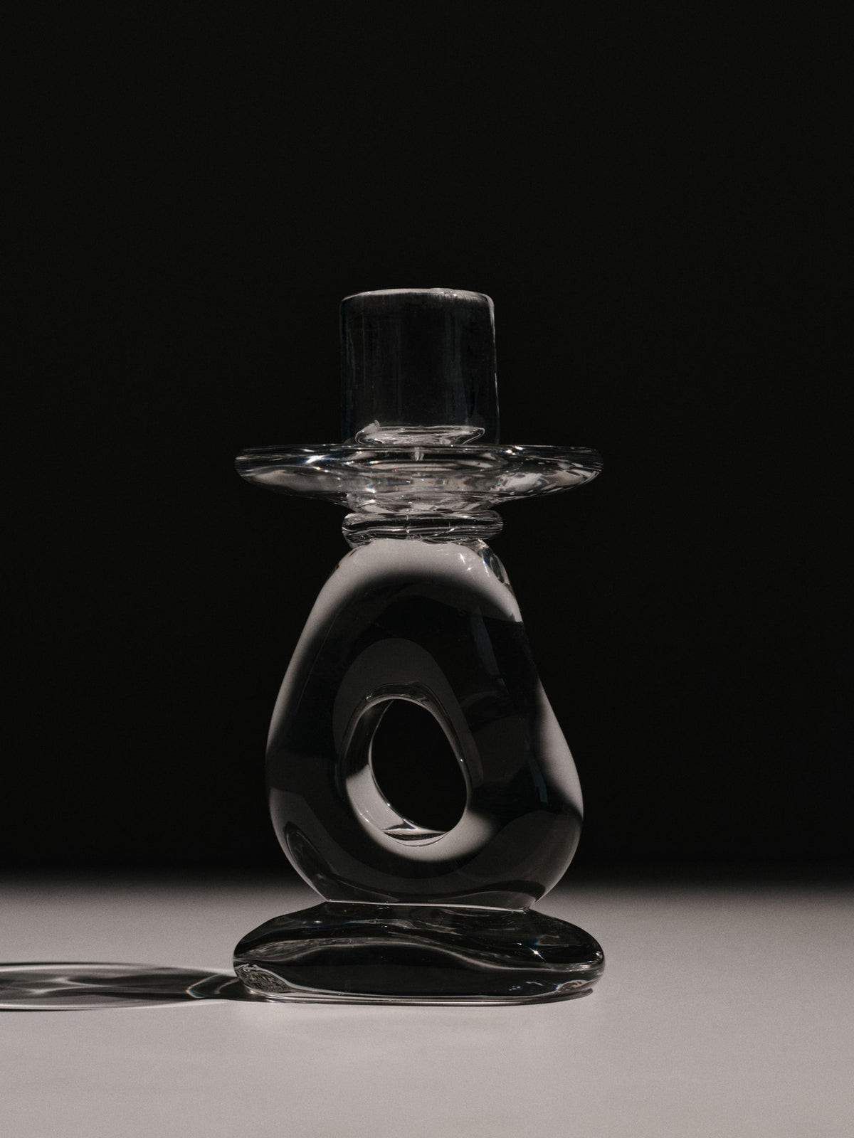 Mundgeblasener Kerzenhalter aus klarem Massivglas mit skulpturaler, fliessender Form, konzipiert für eine einzelne Kerze, Höhe 16 cm.
