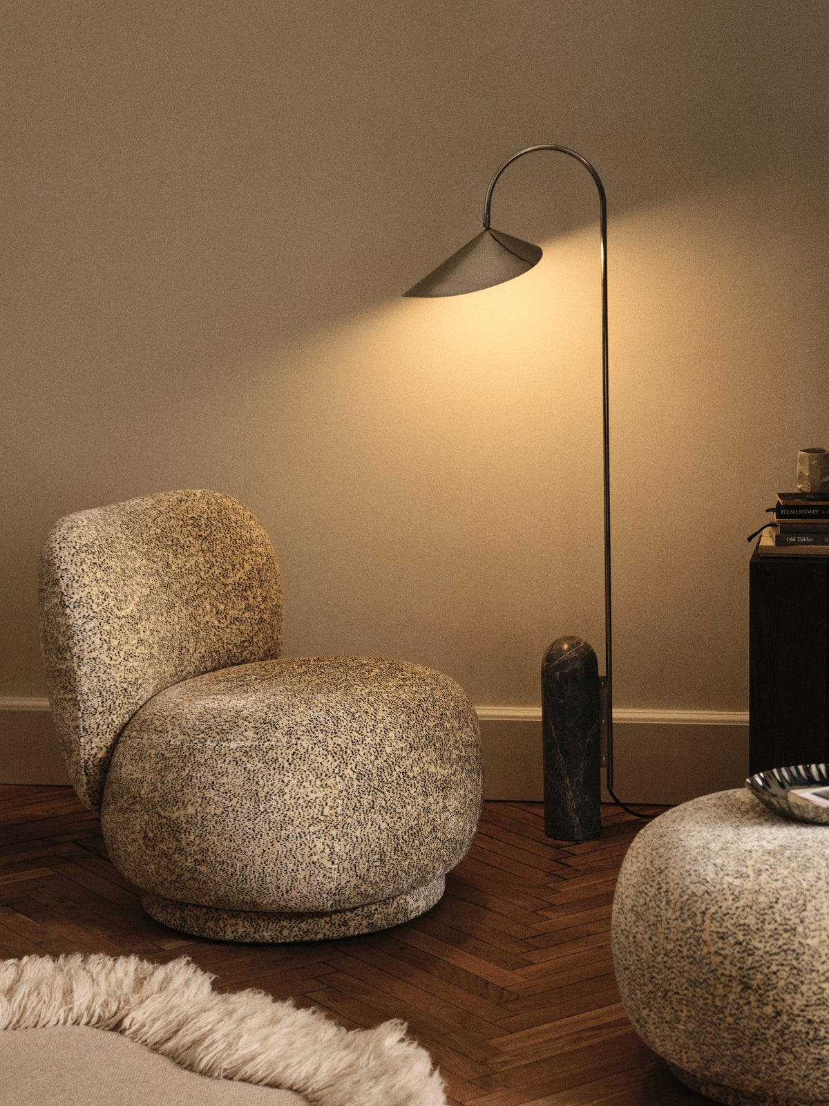 Foto eines Drehsessels Rico Lounge Piccolo von Ferm Living mit Bezug aus Poppy Velvet in Butter/Black, kompakte runde Form und Drehsockel.