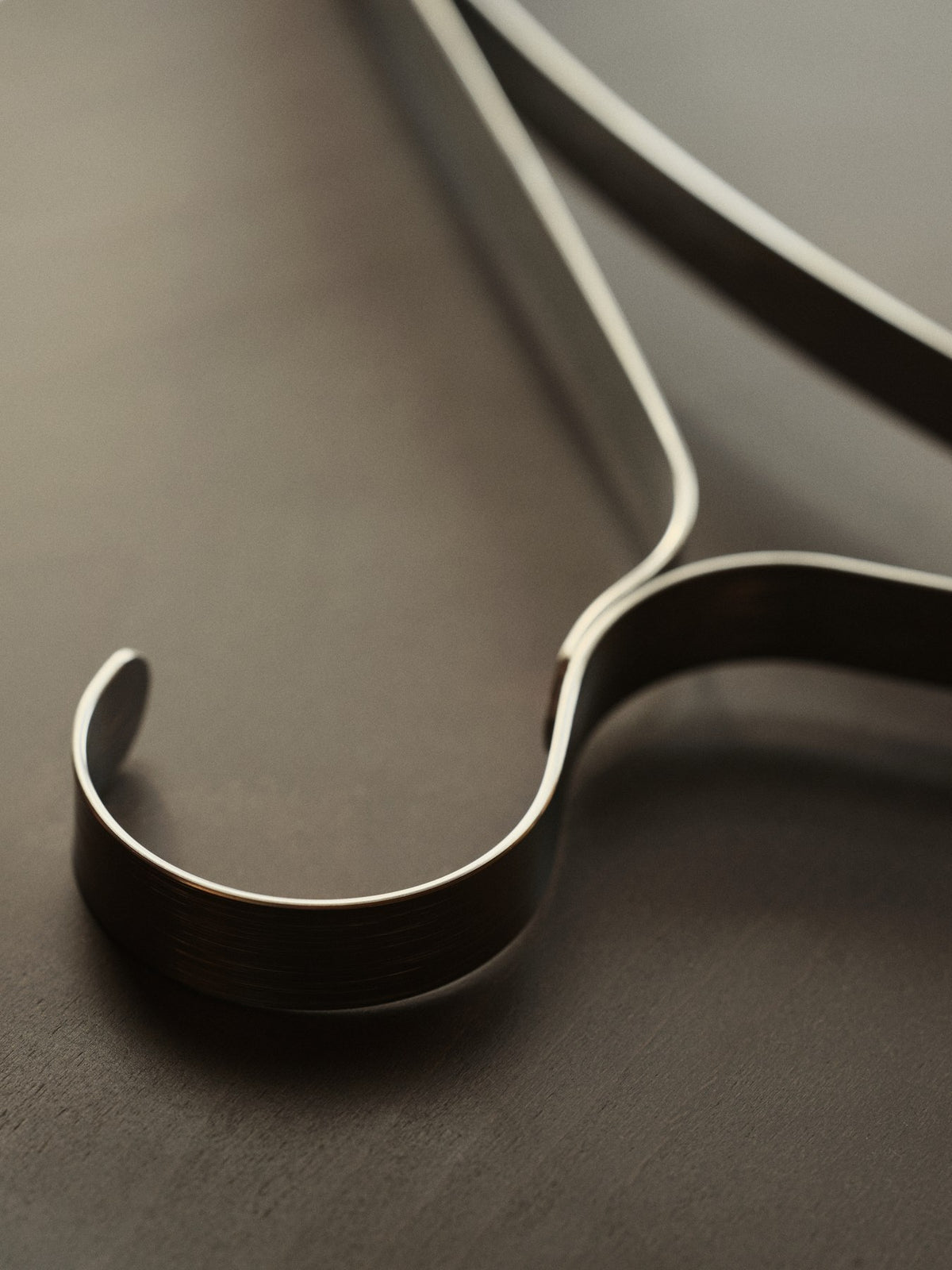 Drei Kleiderbügel aus Edelstahl mit schlanker, durchgehend gebogener Form, im Set von Ferm Living, glänzende Metalloberfläche sichtbar.