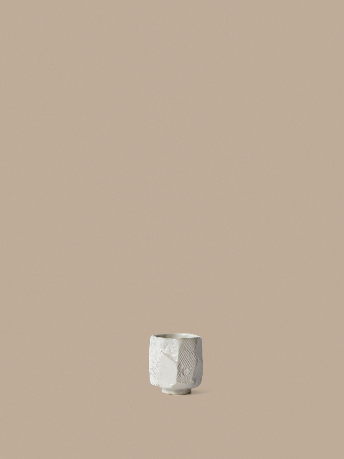 Cremefarbene Toky Tasse aus glasiertem Steinzeug mit organischer, handgefertigter Form und sichtbarer Oberflächenstruktur, Ansicht von vorne.