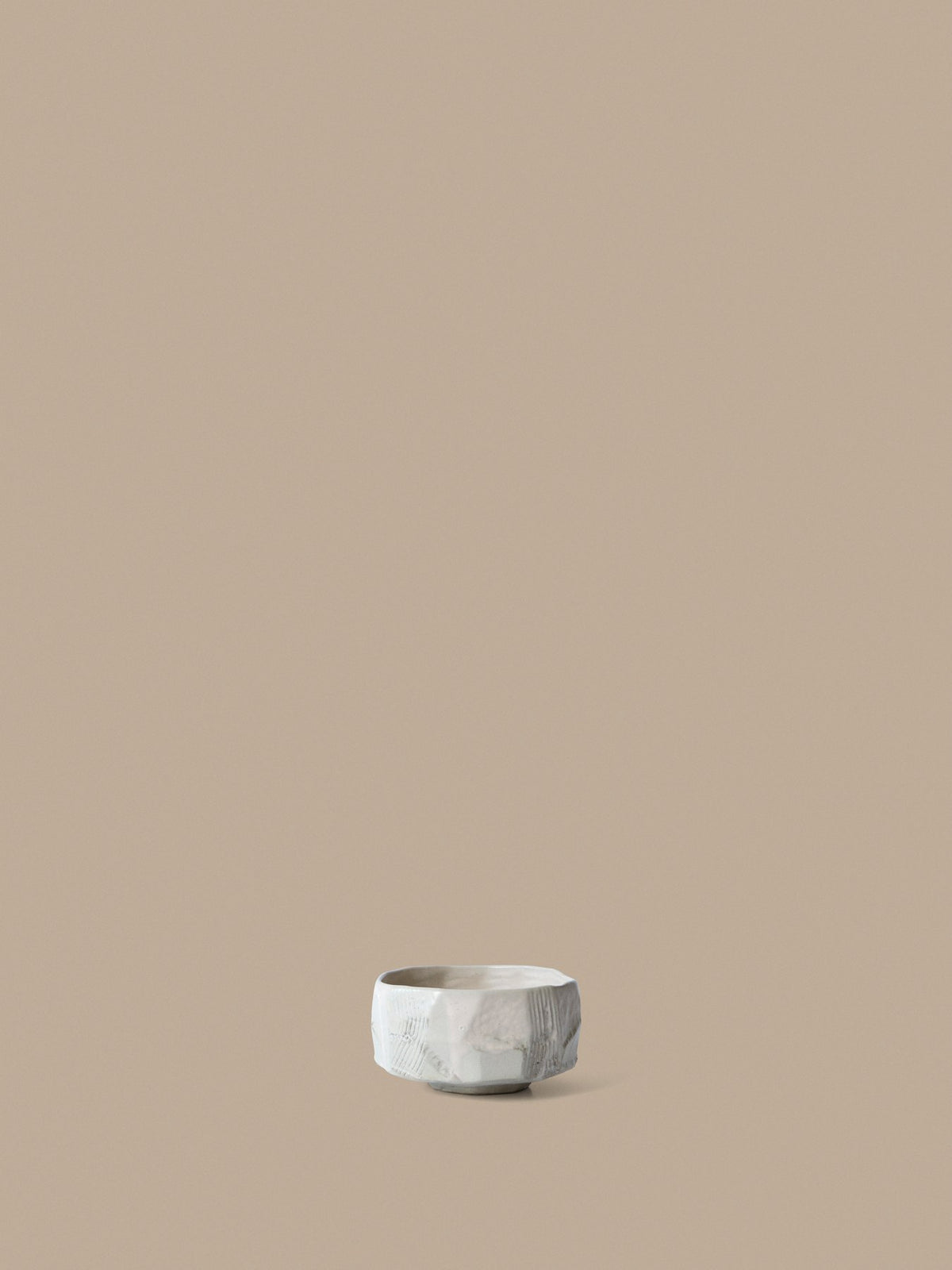 Kleine runde Keramikschale in Creme mit glasierter, unebener Oberfläche und organischer Form, handgefertigt aus Steinzeug.