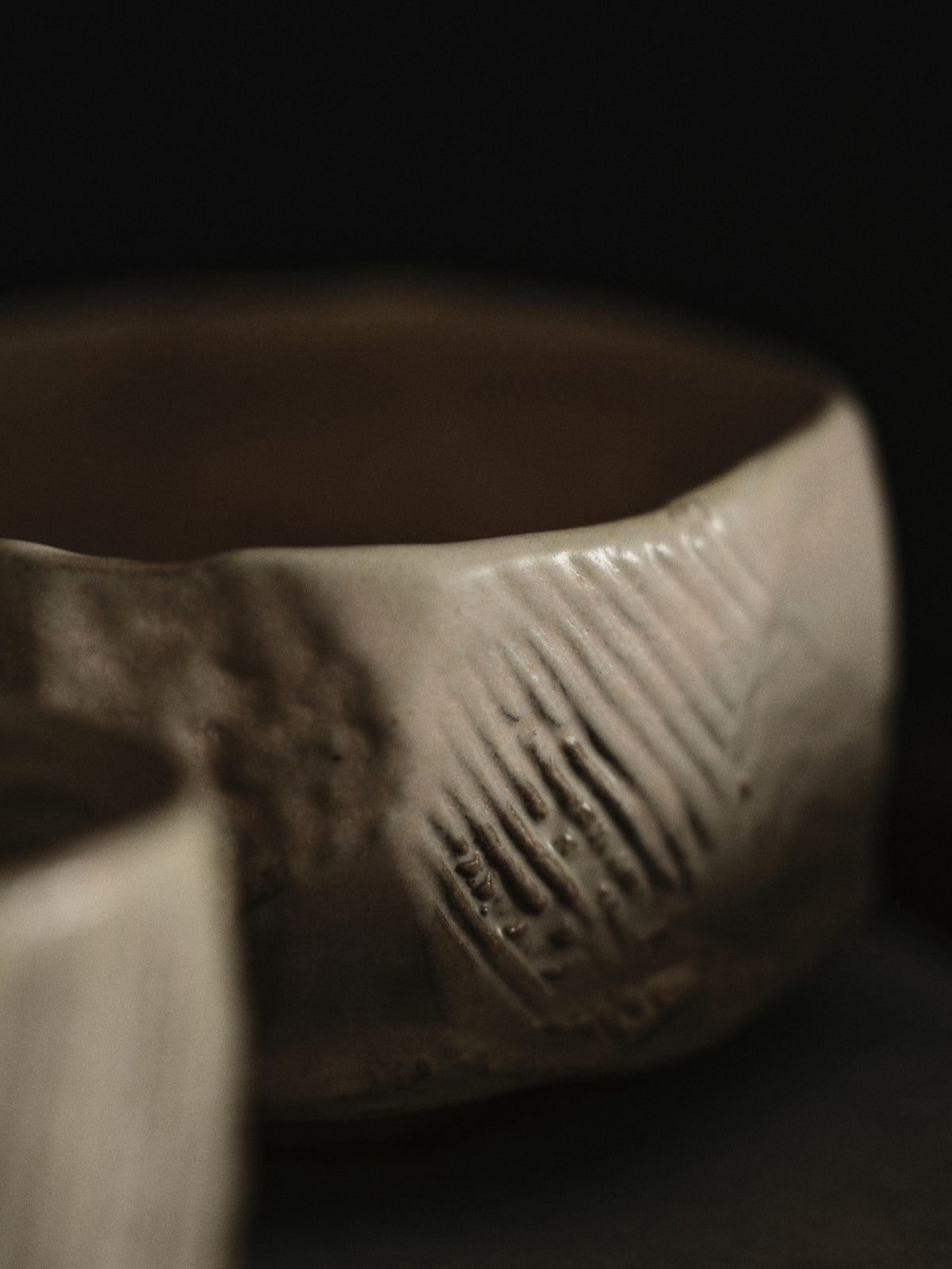 Kleine runde Keramikschale in Creme mit glasierter, unebener Oberfläche und organischer Form, handgefertigt aus Steinzeug.