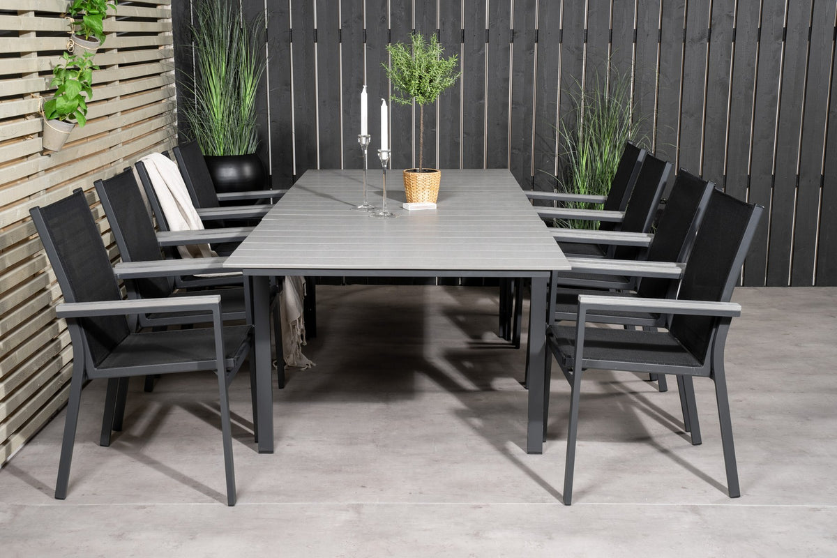 Rechteckiger Esstisch aus Aintwood mit Aluminiumgestell in Anthrazit, dazu zwei stapelbare Stühle mit pulverbeschichteter Oberfläche.