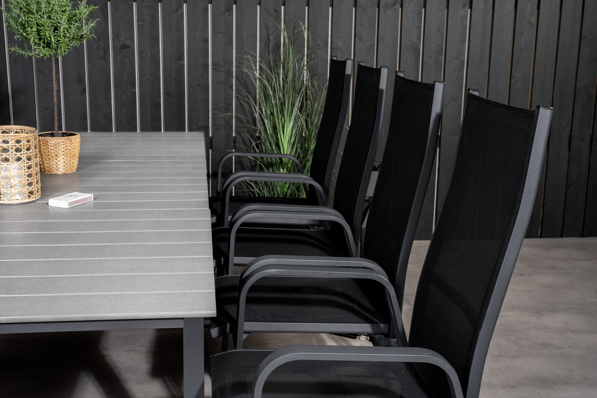 Schwarzer ausziehbarer Gartentisch Levels mit grauer Aintwood-Tischplatte und zwei stapelbaren Copacabana Sesseln aus Aluminium und Aintwood.
