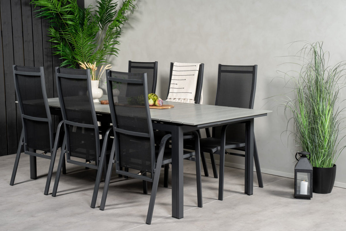 Rechteckiger Gartentisch mit grauer Aintwood-Platte und Aluminiumgestell, daneben zwei stapelbare Copacabana-Relaxsessel in Schwarz.