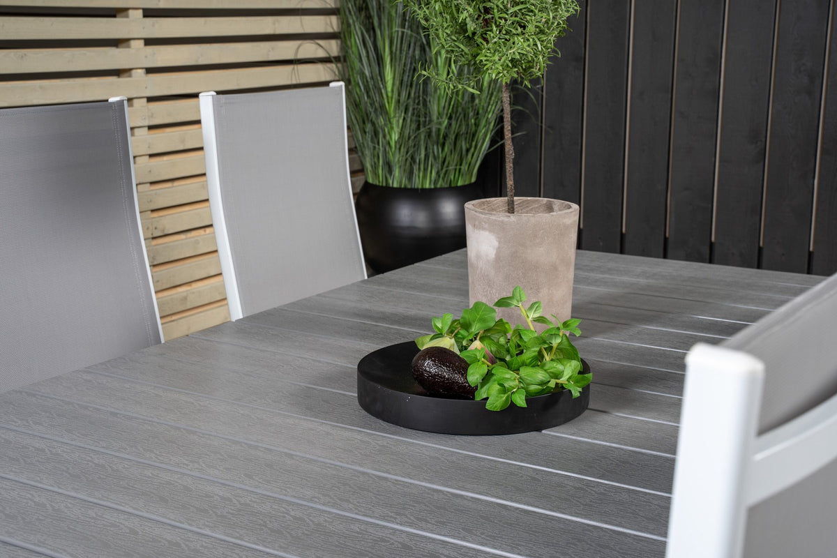 Gartentischset mit ausziehbarem Levels Esstisch aus Aluminium und Aintwood sowie acht stapelbaren Copacabana Stühlen mit grauem Textilene-Bezug.