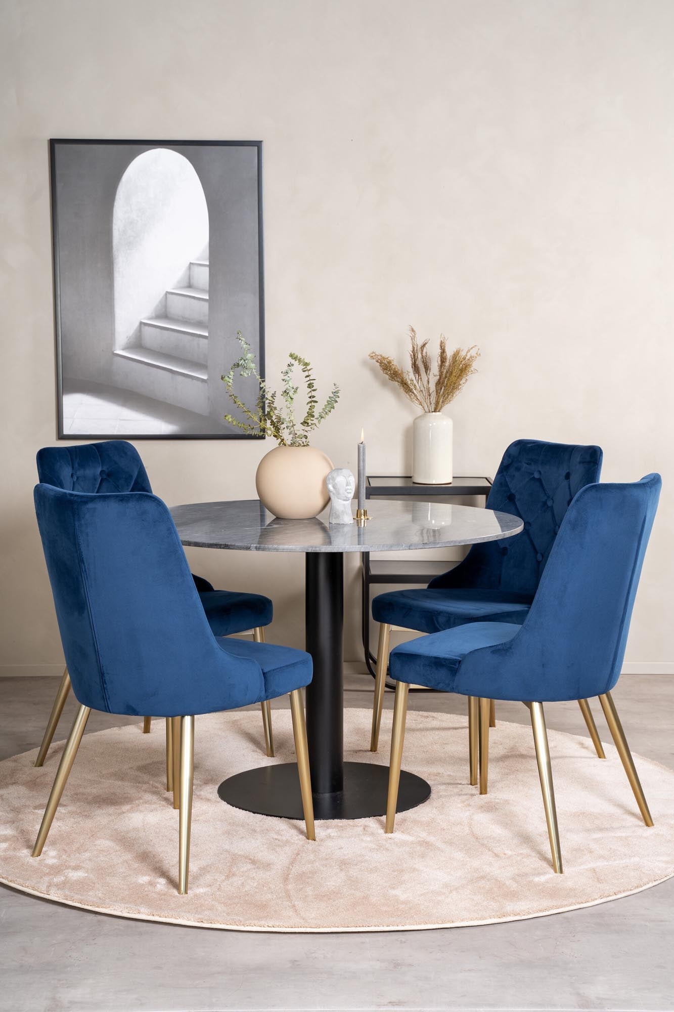 Elegantes Esszimmerset mit runden Tisch und vier Samtstühlen.