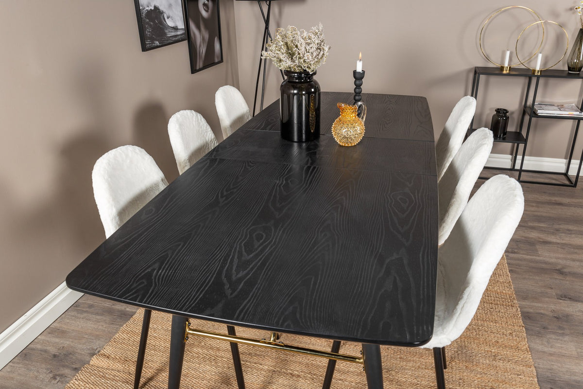 Esszimmerset mit ausziehbarem Esstisch aus MDF mit schwarzer Platte und Stahlbeinen, dazu zwei weisse Stühle aus MDF und Stahl.
