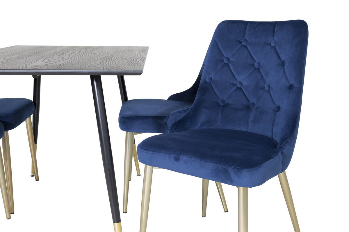 Rechteckiger Esstisch mit schwarzer MDF-Platte und Stahlbeinen, dazu zwei blaue Stühle mit messingfarbener Oberfläche im Esszimmerset.