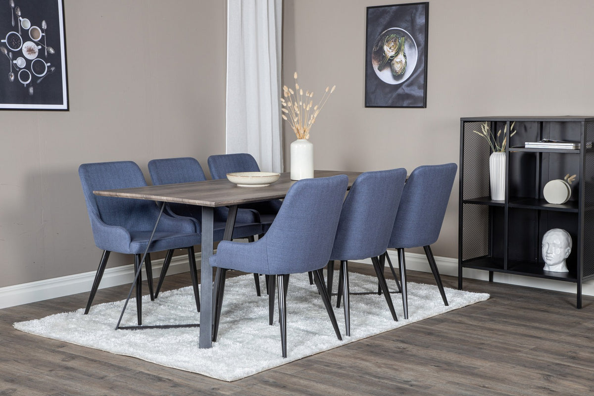 Zwei blaue Esszimmerstühle mit Stahlgestell und schwarz pulverbeschichteter Oberfläche neben einem rechteckigen MDF-Esstisch mit Stahlbeinen.