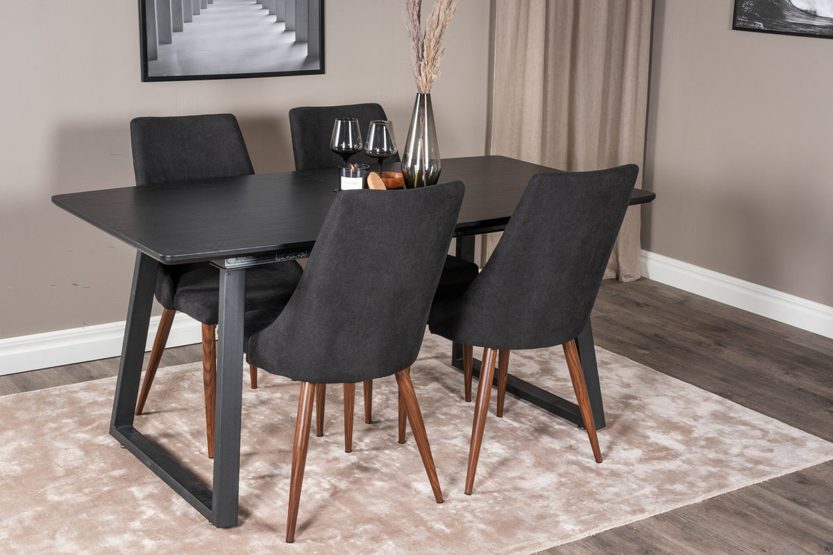 Zwei schwarze Esszimmerstühle mit Stahlbeinen und ausziehbarer schwarzer Esstisch mit MDF-Platte, Serie Leone & Inca von Venture Home.