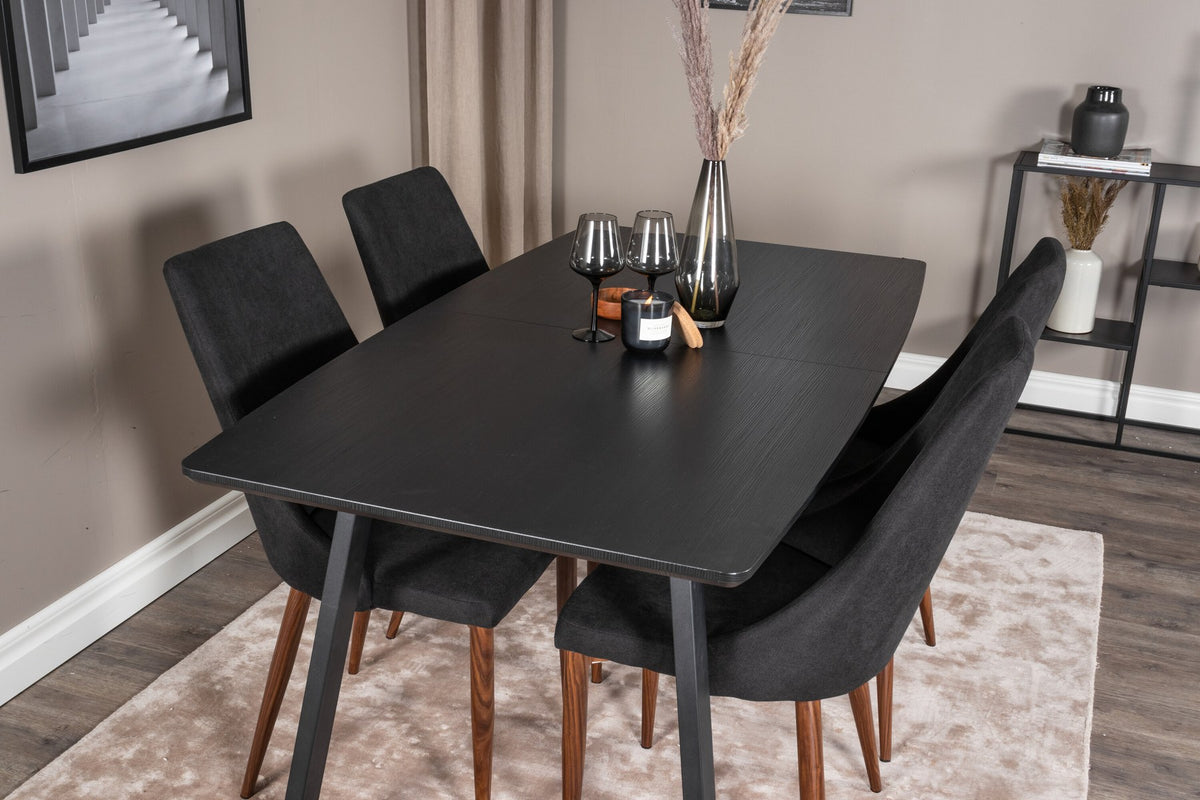 Zwei schwarze Esszimmerstühle mit Stahlbeinen und ausziehbarer schwarzer Esstisch mit MDF-Platte, Serie Leone & Inca von Venture Home.
