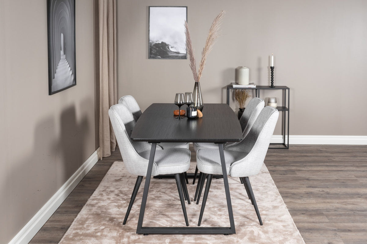 Rechteckiger Esstisch Inca in Schwarz mit ausziehbarer MDF-Platte und Stahlbeinen, daneben zwei gepolsterte Velvet-Esszimmerstühle in Grau von Venture Home.