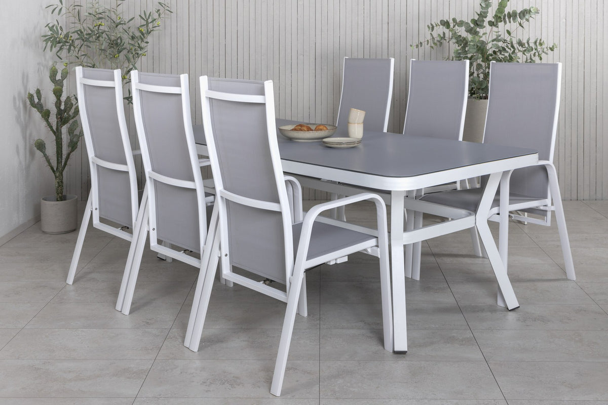 Rechteckiger Gartentisch mit Mattglas-Platte und Aluminiumbeinen, daneben zwei graue Relaxsessel aus Textilene von Venture Home.