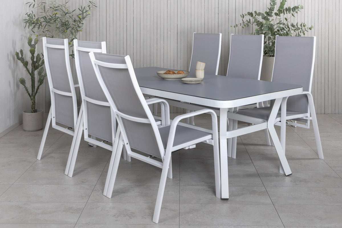 Rechteckiger Gartentisch mit Mattglas-Platte und Aluminiumbeinen, daneben zwei graue Relaxsessel aus Textilene von Venture Home.