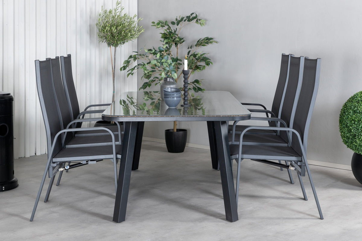 Schwarzer Gartentisch aus Glas und Aluminium mit zwei Relaxsesseln aus Polyesterseil, Stahl und Weide im Outdoor-Bereich.