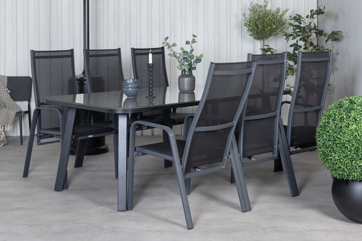 Schwarzer Gartentisch aus Glas und Aluminium mit zwei Relaxsesseln aus Polyesterseil, Stahl und Weide im Outdoor-Bereich.