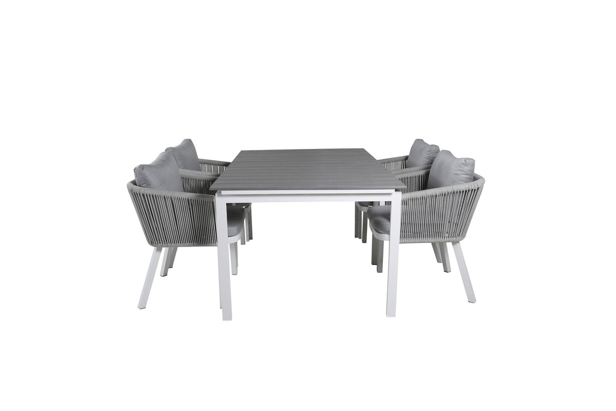 Zwei graue Esszimmerstühle mit Seil-Bezug und Aluminiumgestell neben einem weissen, ausziehbaren Aintwood-Esstisch im Garten.