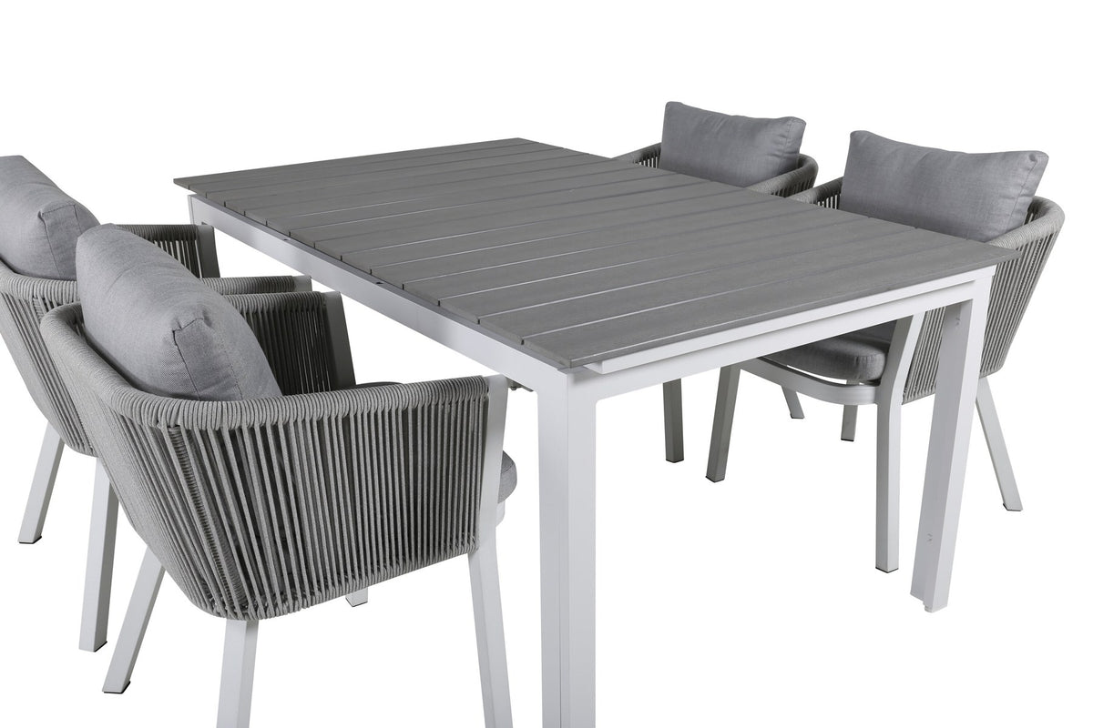 Zwei graue Esszimmerstühle mit Seil-Bezug und Aluminiumgestell neben einem weissen, ausziehbaren Aintwood-Esstisch im Garten.