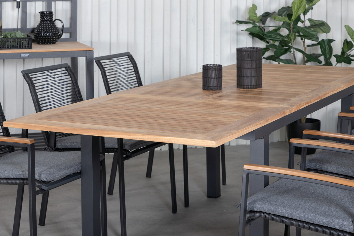 Zwei schwarze Aluminium-Stühle mit Polyester-Bezug und ein rechteckiger, ausziehbarer Teak-Tisch mit schwarzer Tischplatte.