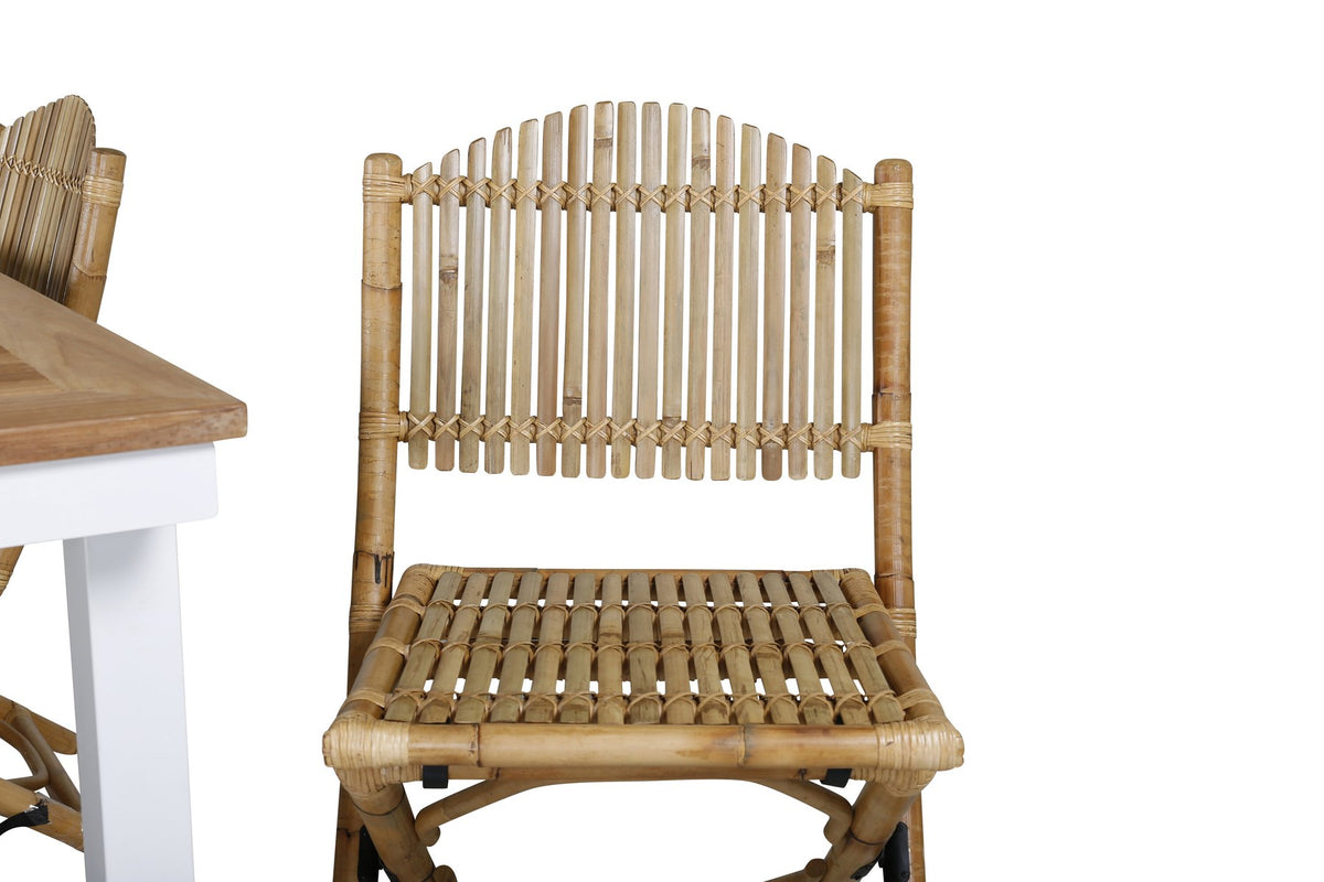 Foto zeigt einen Cafe Stuhl mit Rattan-Beinen und Stoffbezug in Natur sowie einen rechteckigen Teakholz-Esstisch mit weissem Aluminiumgestell.