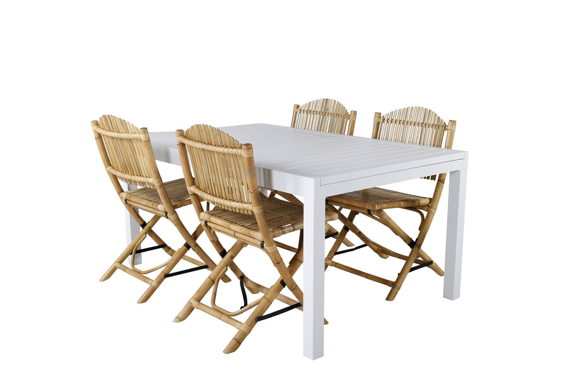 Aluminium-Caféstuhl in Natur mit Baumwoll-Polyester-Bezug neben rechteckigem Esstisch mit weisser Aluminium-Tischplatte und Rattanbeinen.
